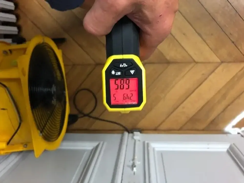 Thermomètre infrarouge affichant 58,9 °C au cœur de la pièce en cours de traitement